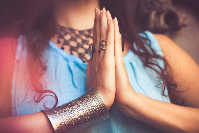 women holding her hands together and saying namaste